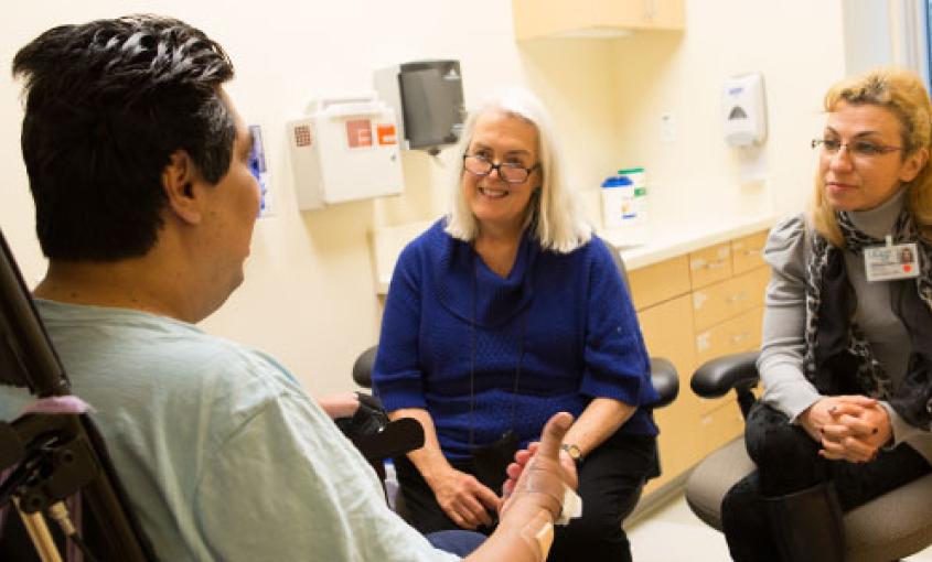 Anne Hughes (center) and student Julia Itsikson (right) consult with a patient at Laguna Honda Hospital and Rehabilitation Center in San Francisco (photo by Elisabeth Fall). 