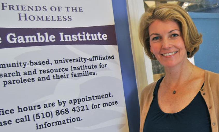 Elizabeth Marlow stands next to a sign for the The Gamble Institute.