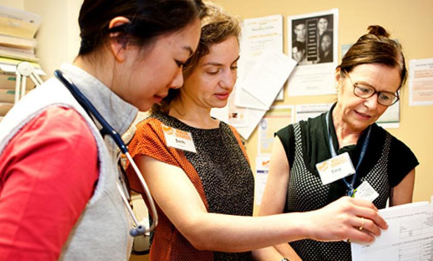 Residents Vivian Sha (left) and Beth Goldstein (center) consult with NP Tina Clark at Glide Health Services clinic in San Francisco (photos by Elisabeth Fall).