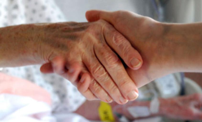 A patient shakes the hand of a health care provider.