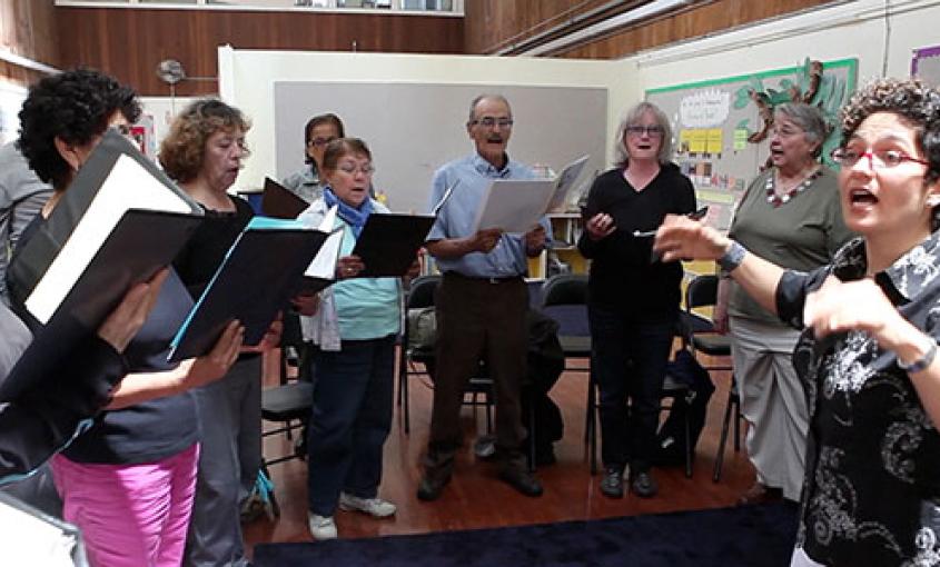A choir of seniors at San Francisco’s Mission Neighborhood Centers is led by Community of Voices Choir conductor Martha Rodriguez-Salazar (still from video by Elisabeth Fall).