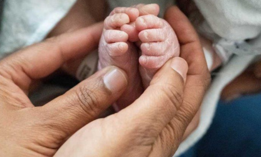 Adult holding baby's feet