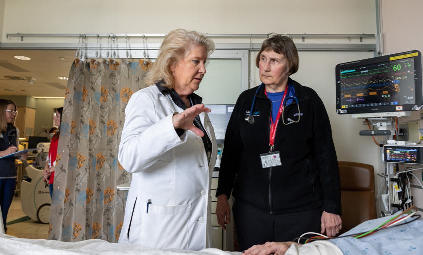 Michele Pelter, PhD, RN, speaks to Kirsten Fleischmann, MD, MPH, and a patient from a hospital room in the cardiac ICU. 