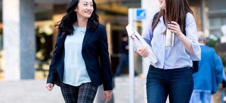 Cherry Leung smiling and walking with a student. 
