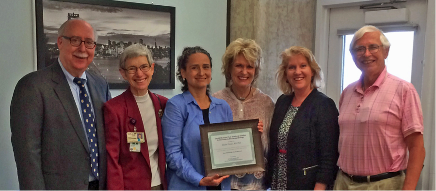 Dean David Vlahov, Professor Meg Wallhagen, Post-Doctoral Fellow Adelita Tinoco, Professor Barbara Drew, Professor Michele Pelter, and Associate Adjunct Professor David Mortara pose with fellowship plaque.